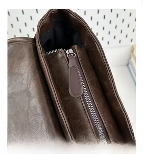 Macro shot of smooth metal zipper and reinforced stitching on dark brown leather backpack