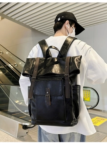 Detail view of vintage black PU leather backpack with brown straps and metal buckles