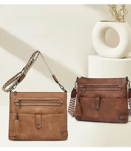 Close-up of vintage washed leather crossbody bag with fringe detail and woven strap