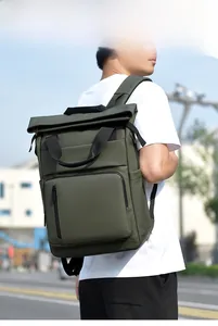 Outdoor model wearing a dark green roll-top business backpack with front zipper pocket