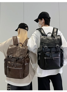 Rear view of models wearing retro PU leather backpacks in black and brown finishes
