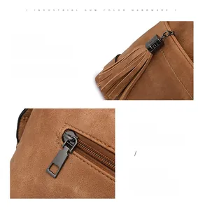Detail of gunmetal hardware and fringe tassel zipper on a brown suede shoulder bag