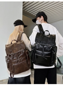 Detail view of vintage PU leather backpacks with drawstring closure and buckle straps
