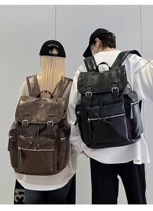 Detail of black and brown PU leather backpacks with multiple metal zipper pockets
