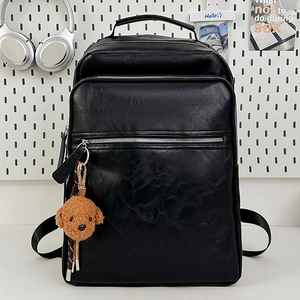 Retro multi-pocket black leather backpack with a plush poodle charm and metal zippers