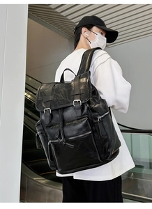 Detail of vintage black leather backpack with flap buckles and multiple zipper pockets