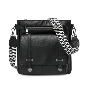 Close-up of litchi texture faux leather and geometric woven strap on black bucket bag