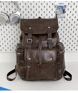 Detail of dark brown vintage PU leather backpack with buckle straps and side zippers