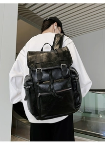Close-up of black PU leather backpack featuring dual-buckle closure and large capacity