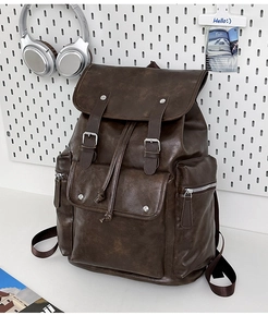 Detail of dark brown PU leather backpack with buckle straps and drawstring closure