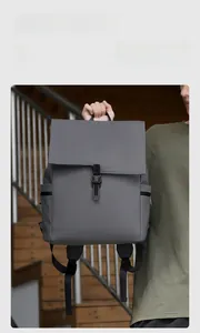 Dark grey waterproof commuter backpack with flip-top buckle in a lifestyle stair setting