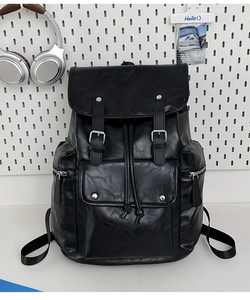 Detail view of the black PU leather backpack showing flap closure and front pocket