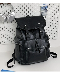 Close-up of black PU leather backpack showing lychee texture and silver metal buckles