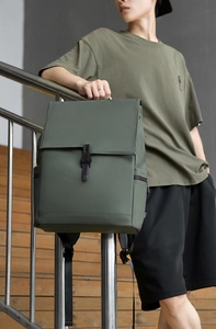 Deep olive green waterproof commuter backpack with buckle flap closure on male model