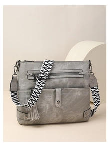 Detail of gray washed faux leather bag featuring a zigzag pattern adjustable strap