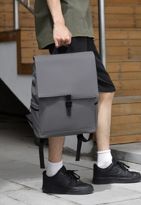 Side view of matte grey waterproof backpack with flap closure and black buckle detail