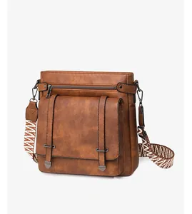 Detail of vintage brown leather crossbody bag with flap pocket and woven strap