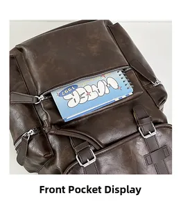 Close-up of brown vintage leather backpack showing front pocket space with a notebook