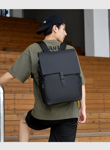 Men's matte waterproof black backpack with buckle closure shown in an outdoor lifestyle setting