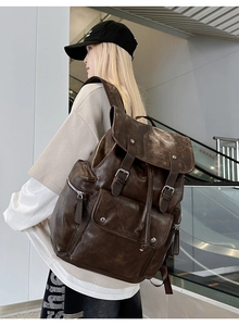 Detailed view of a vintage brown PU leather backpack worn by a model in a modern setting
