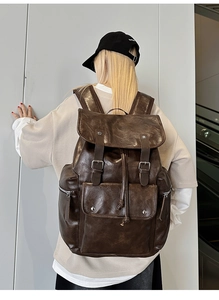 Close-up of deep brown oil-wax faux leather backpack with drawstring and magnetic buckle