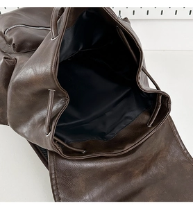 Detail of vintage brown PU leather backpack featuring drawstring closure and spacious interior