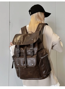 Detailed back view of a large brown vintage PU leather backpack with silver metal buckles