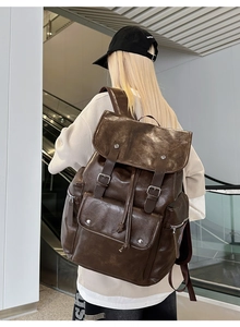 Rear view of vintage brown PU leather backpack with multiple pockets in modern setting