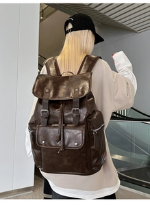 Close-up of brown PU leather backpack featuring magnetic buckles and drawstring closure