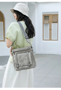 Detail of grey bucket bag with a wide geometric strap and vintage marble texture