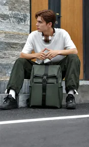 Olive green roll-top waterproof backpack with buckle closure shown in outdoor lifestyle shot
