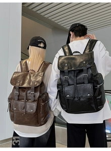 Rear view of models wearing vintage PU leather backpacks in dark brown and black