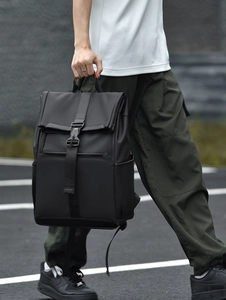 Detail of waterproof black commuter backpack featuring roll-top closure and side pocket