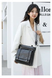 Detail of vintage black textured leather bucket bag with geometric patterned strap on model