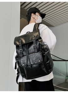 Detailed view of black PU leather backpack with vintage buckle flap and side zippers