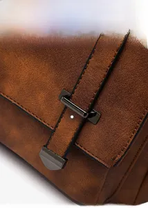 Macro detail of dark brown suede bag featuring vintage dark gunmetal buckle hardware
