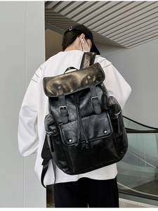 Close-up of black PU leather backpack showing flap closure and magnetic buckles
