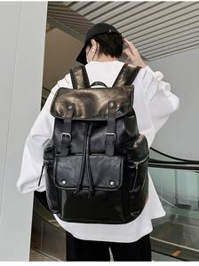 Detailed view of black PU leather backpack with buckle straps and drawstring closure