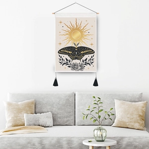 Bohemian sun and moth tapestry with wooden pole and black tassels on white wall