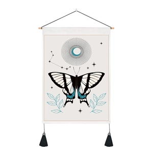 Detail of butterfly and moon tapestry featuring elegant black tassels and a wooden hanging rod
