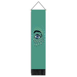 Detailed shot of bohemian Evil Eye tapestry with blue eye pattern and black bottom tassels