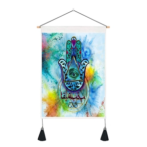 Hamsa Hand and Evil Eye tapestry with colorful paint splatter and black tassels detail