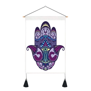 Detail of Hamsa Hand tapestry with purple mandala pattern and black tassels on white fabric