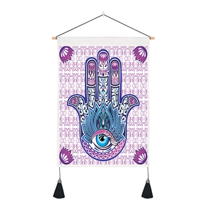 Detail of Hamsa Hand and Evil Eye tapestry with purple tassels and wooden rod