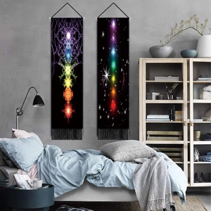 Meditation energy tapestries with chakra patterns and black tassels on a grey wall