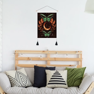 Minimalist butterfly and moon wall tapestry with tassels hanging in a cozy bedroom