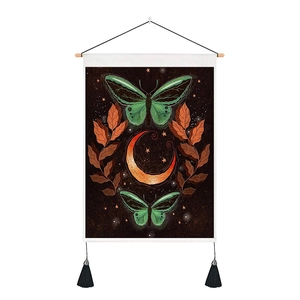 Detail of artistic butterfly and moon tapestry with wooden rod and black tassel accents