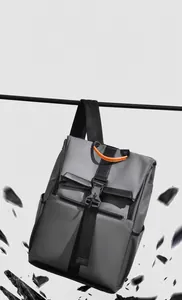 Macro view of water-resistant gray business backpack with orange handle and splash effect
