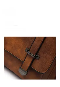Detailed macro view of vintage brown matte bucket bag with dark gunmetal buckle and stitching