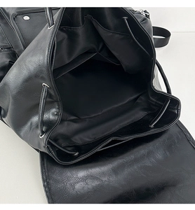 Detail view showing large storage capacity and interior pockets of the black leather backpack